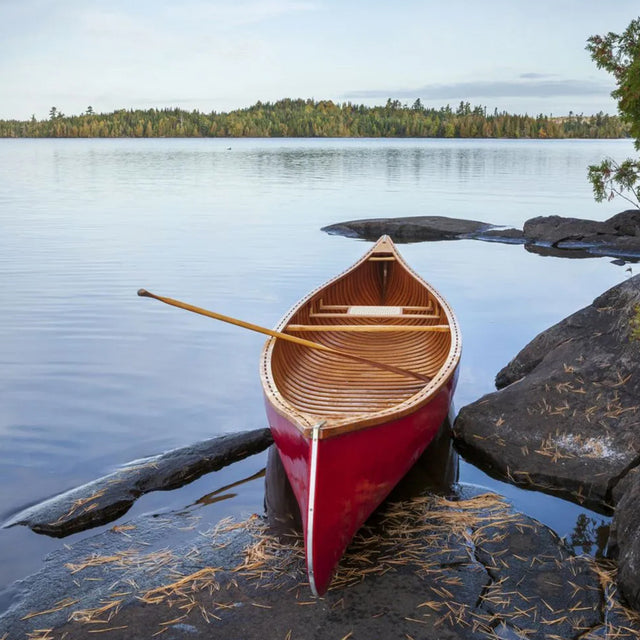 Red wood canoe on rocky shore of a Boundary Waters lake