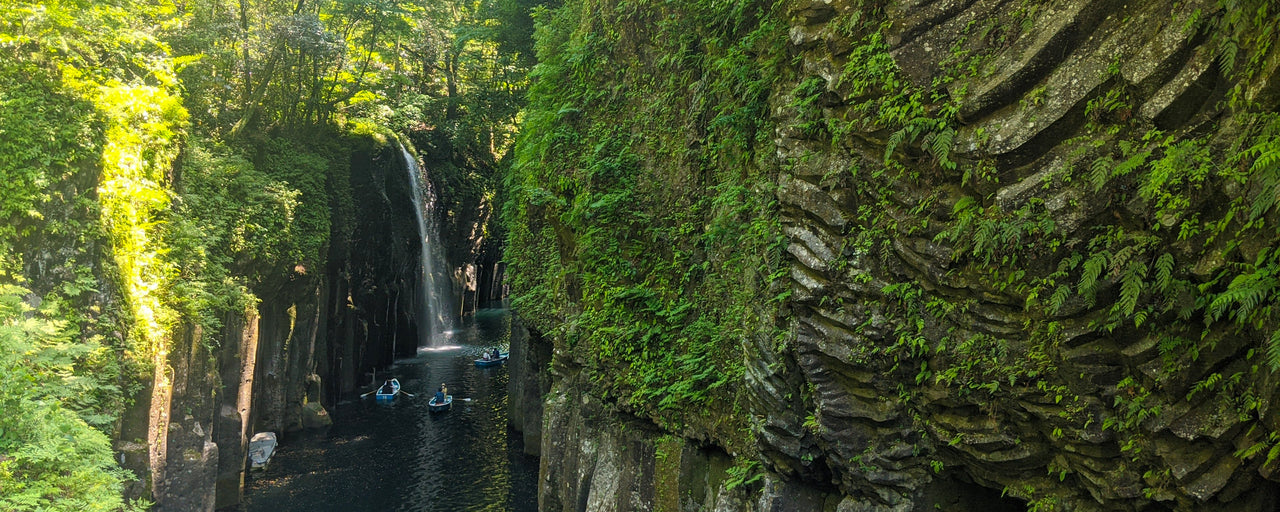 View of the cliffs and tradional rowboats in Manai Falls in Takachiho Gorge