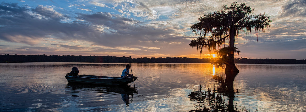 Fisherman in boat at sundown in Louisiana 