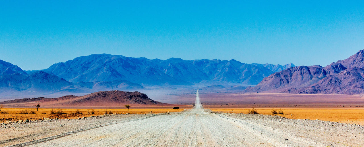 Gravel road in Namibia with a view of mountains