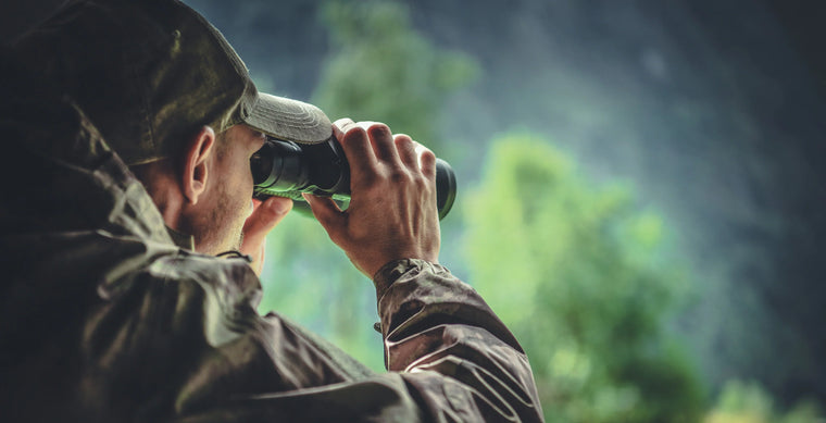  Man Looking Through Binoculars Against Tree 