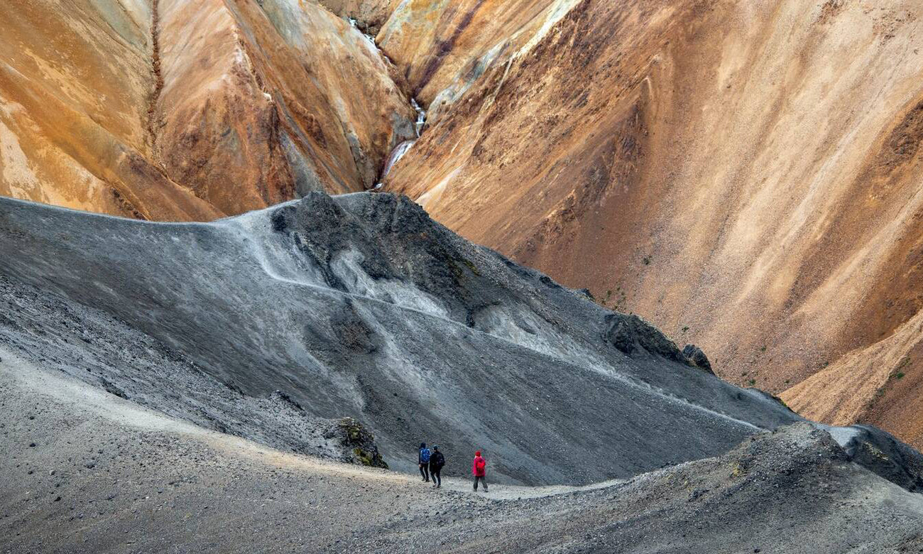 Hikers in volcanic mountains of Landmannalaugar in Fjallabak Nature Reserve