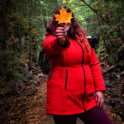 Stephanie on a trail holding a fall leaf