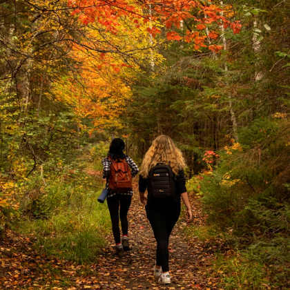 Stephanie and a friend wandering through a trail in Autumn