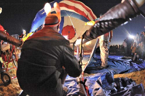 People setting up a hot air balloon at the festival