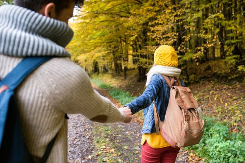 Couple walking through a trail in the fall