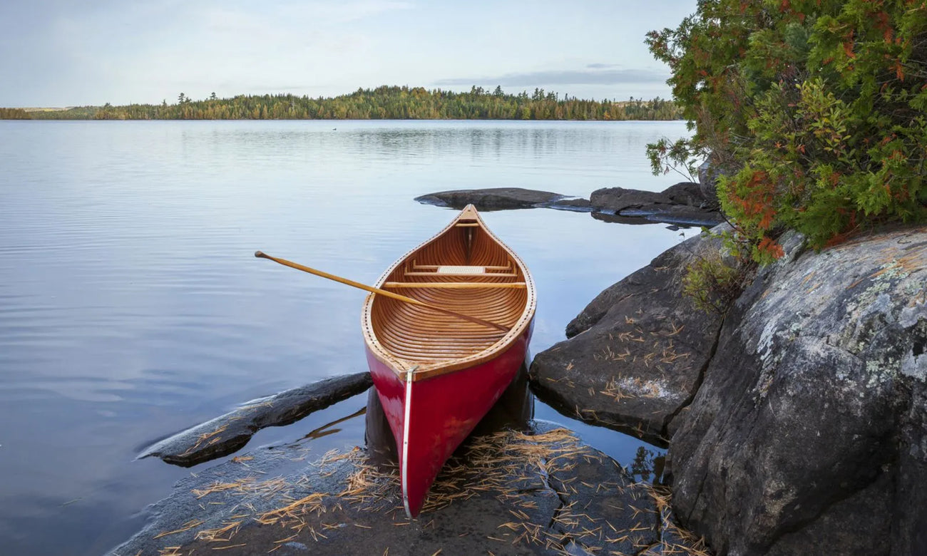 Red wood canoe on rocky shore of a Boundary Waters lake