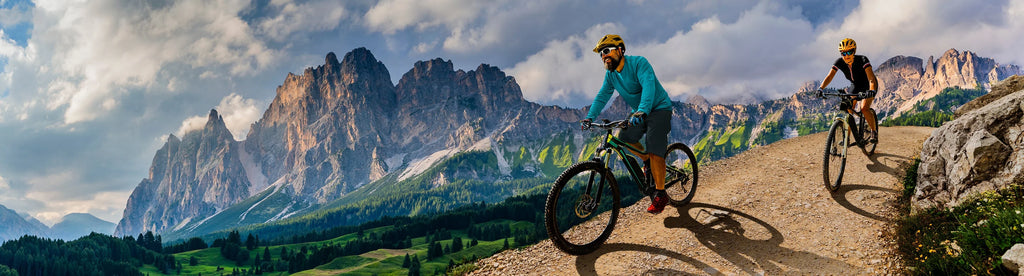 Woman and man riding on bikes in Dolomites mountains