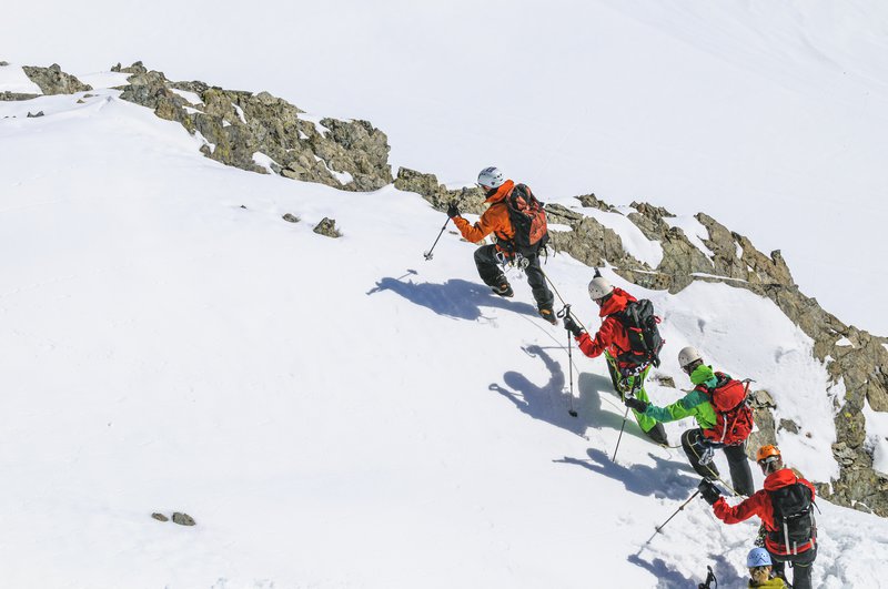 Hikers climbing a snowy mountain