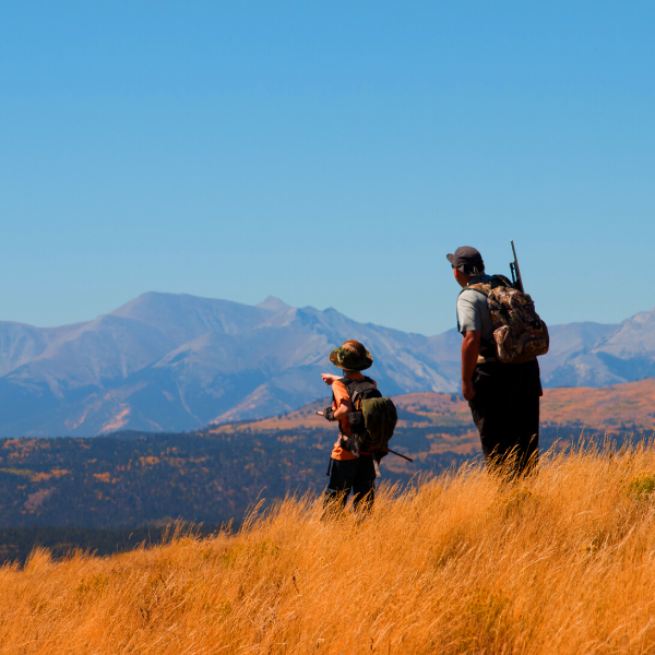 Hunters in field with mountains in the background