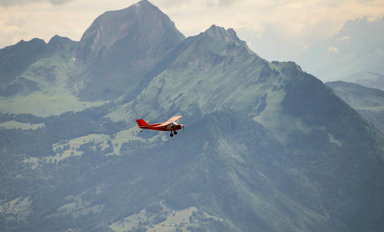 Small red airplane flying over the French Alps