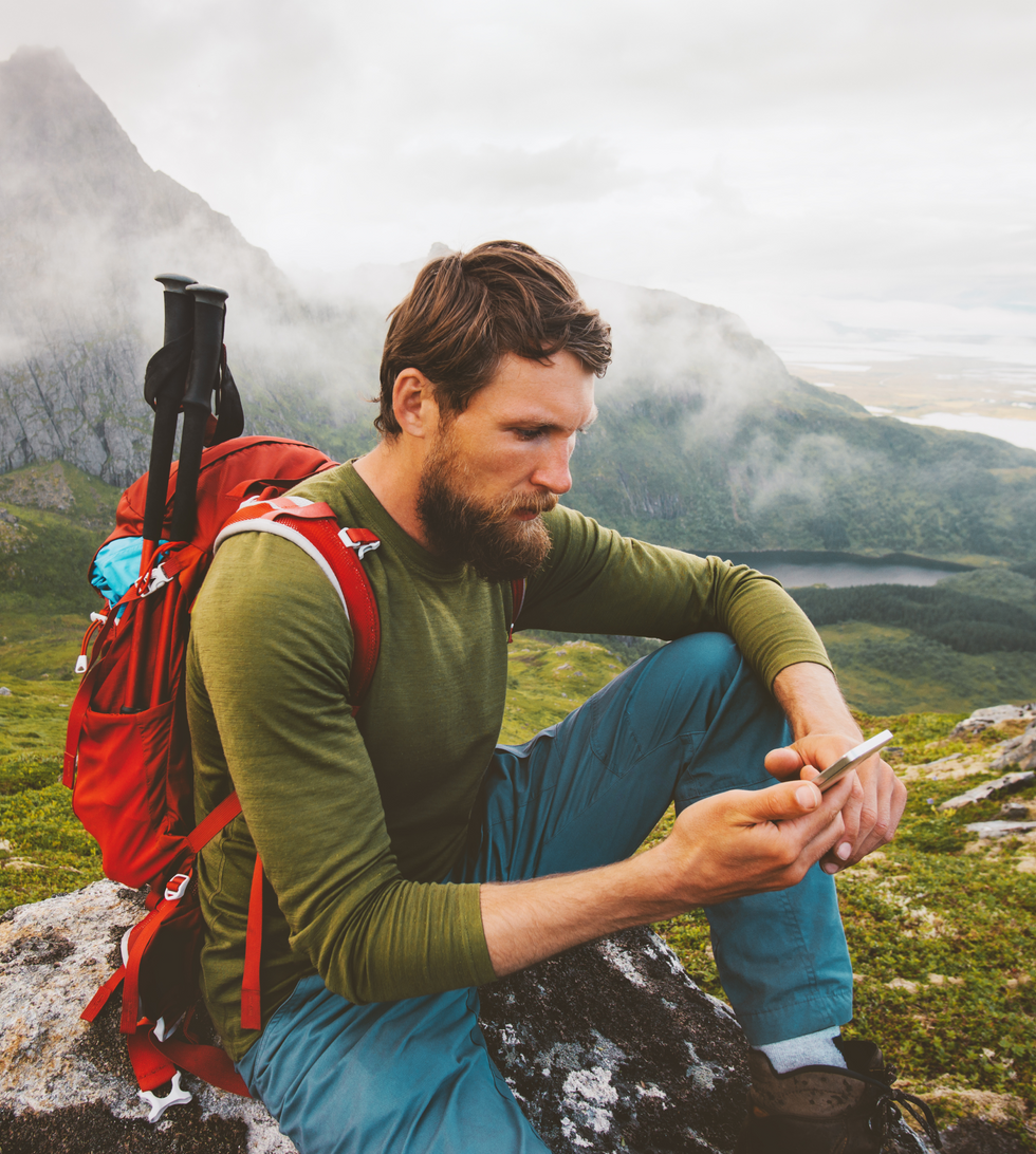 Hiker using his phone in mountains 