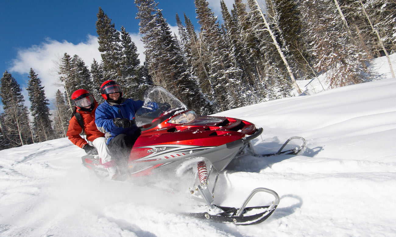 Two people riding a snowmobile