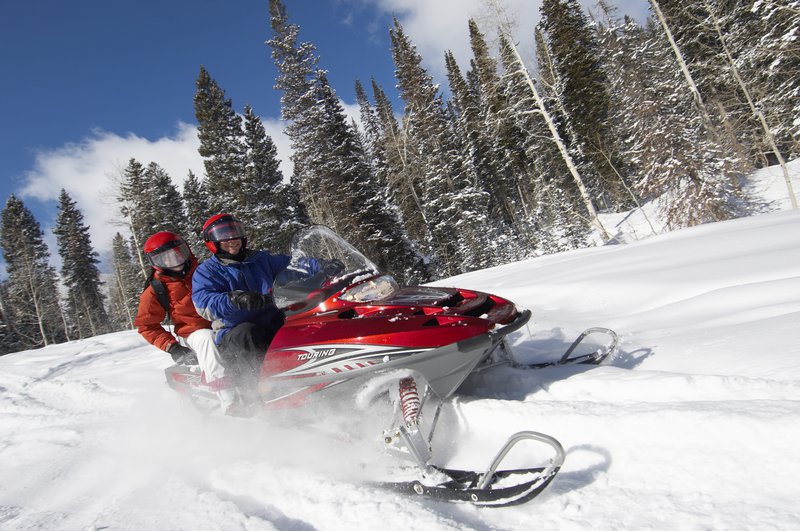 Two people riding a snowmobile